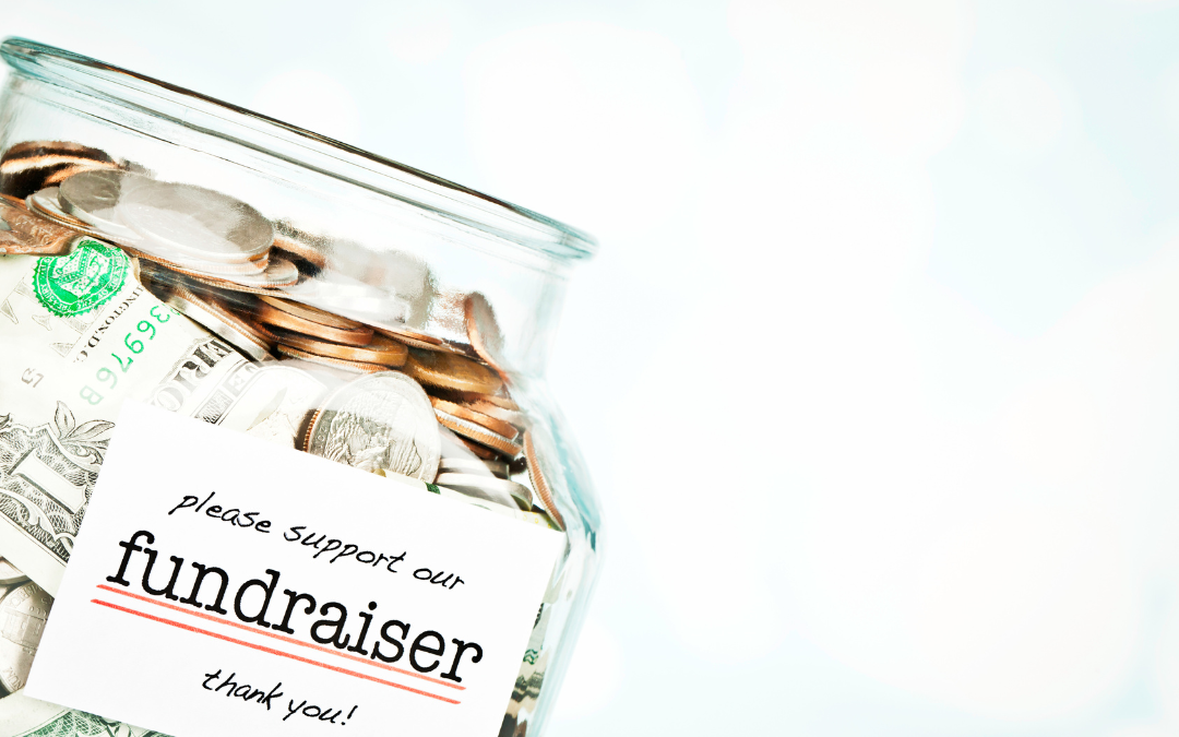 jar of mone with coins and paper money in it with a note on the front that says please support our fundraiser thank you