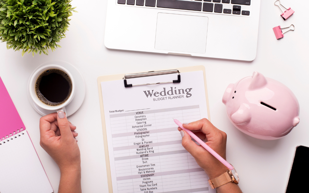 Person with coffee, computer and wedding budget planner alongside a piggy bank