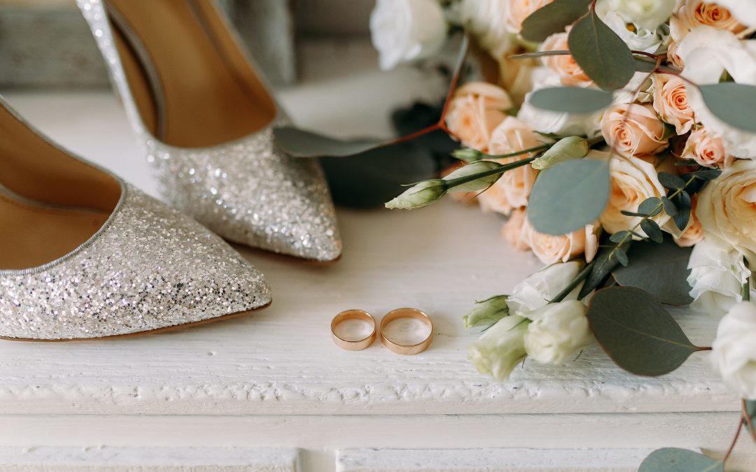 Shiny silver shoes, wedding bands and flowers