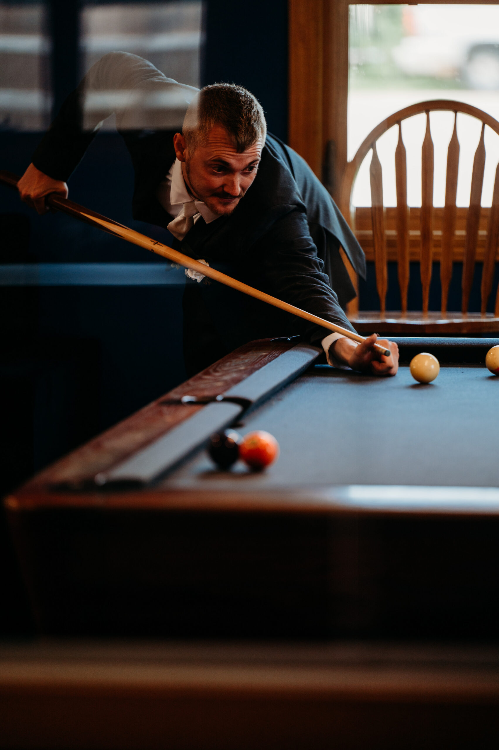 Groom playing pool.