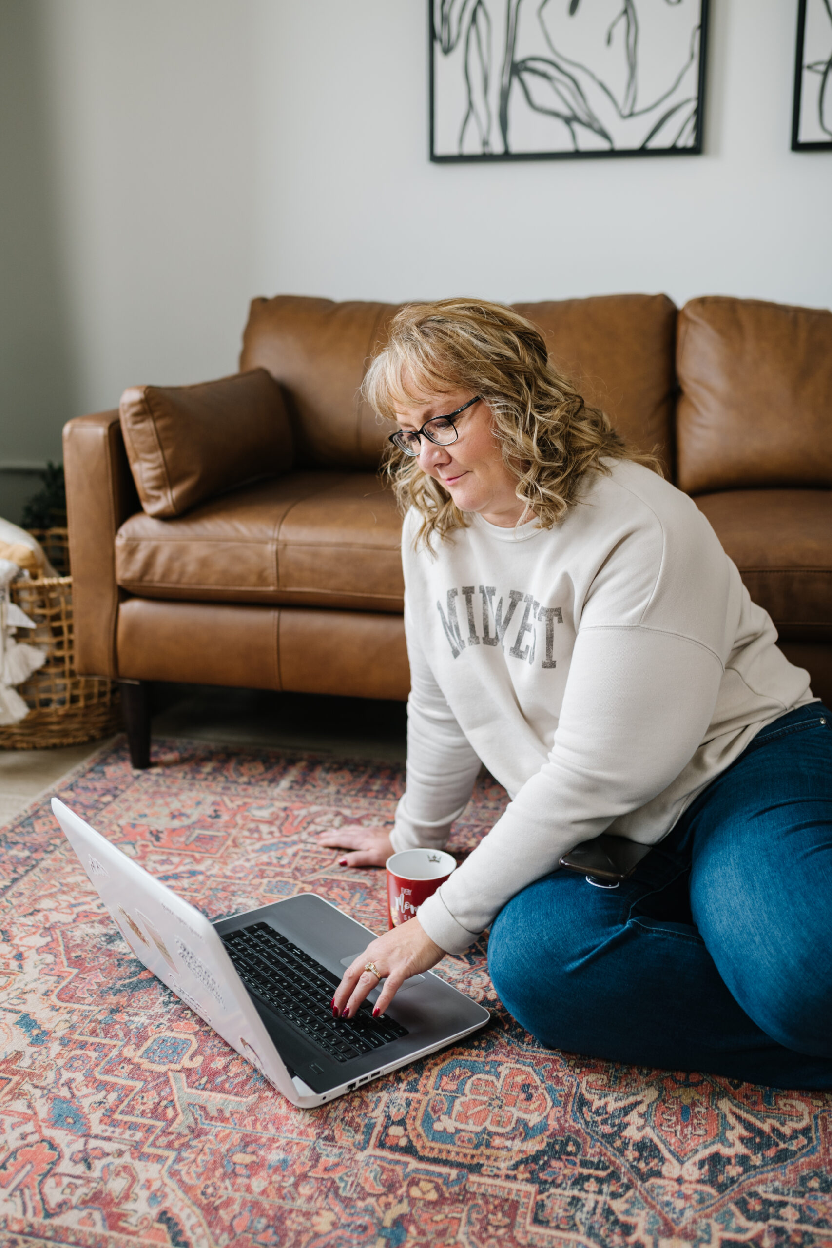 Woman sitting on the floor on the computer.